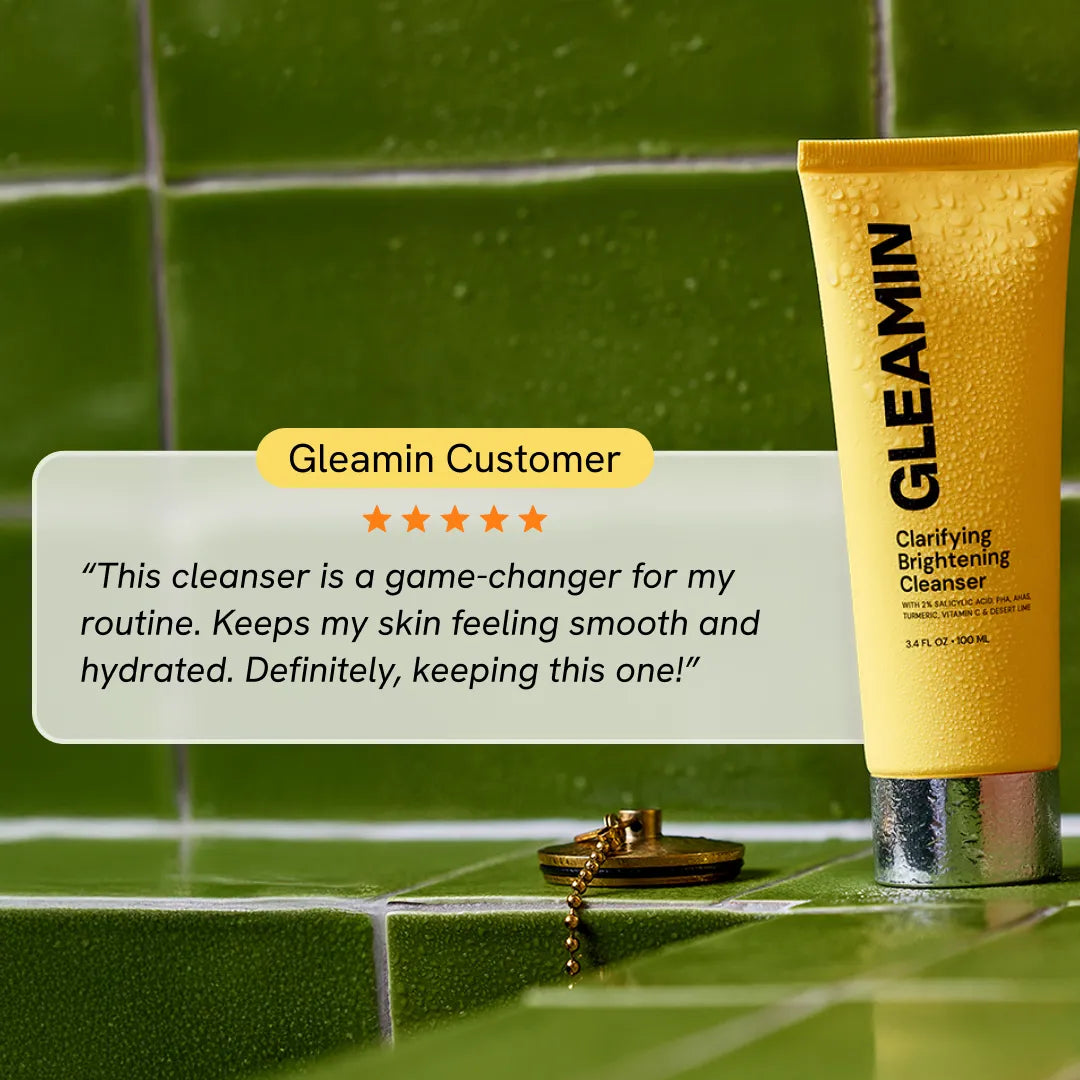 Gleamin Clarifying Brightening Cleanser tube on green tiles with five-star customer review quoting smooth skin benefits.